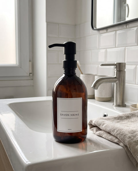 Distributeur de savon Sweet Label à pompe noire sur un lavabo