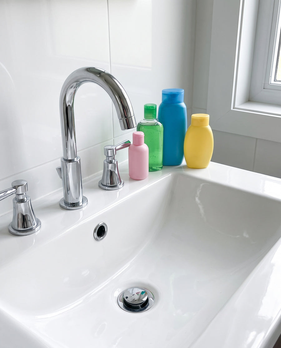 Lavabo avec des flacons de supermarché dépareillés